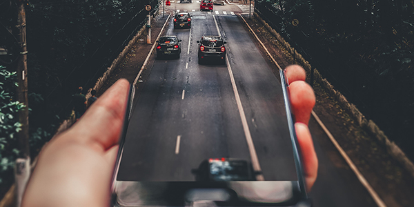 Collaborative and user-driven innovation tools Man holding a road with cars in his hand