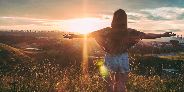 Woman with open arms looking at the city