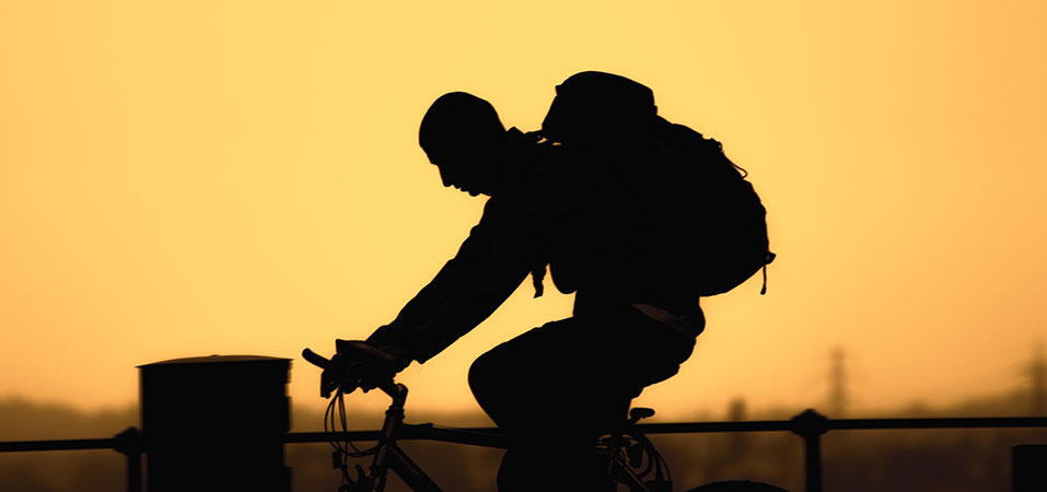 man silhouette on bicycle