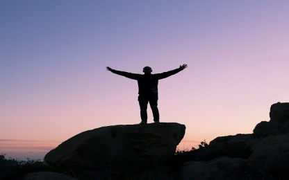 man with open arms on mountain